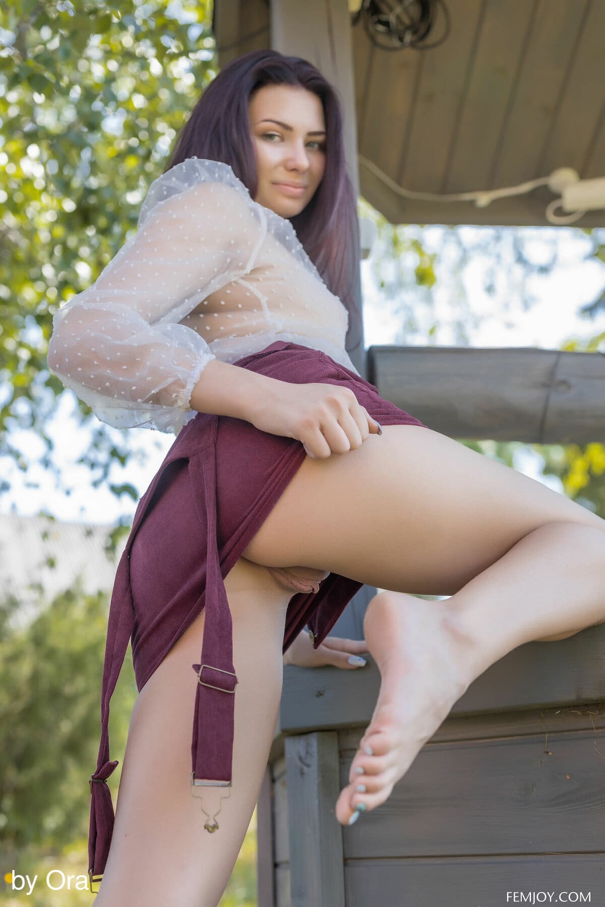 Nana O is swinging naked out of her purple dress at the foot of a fountain