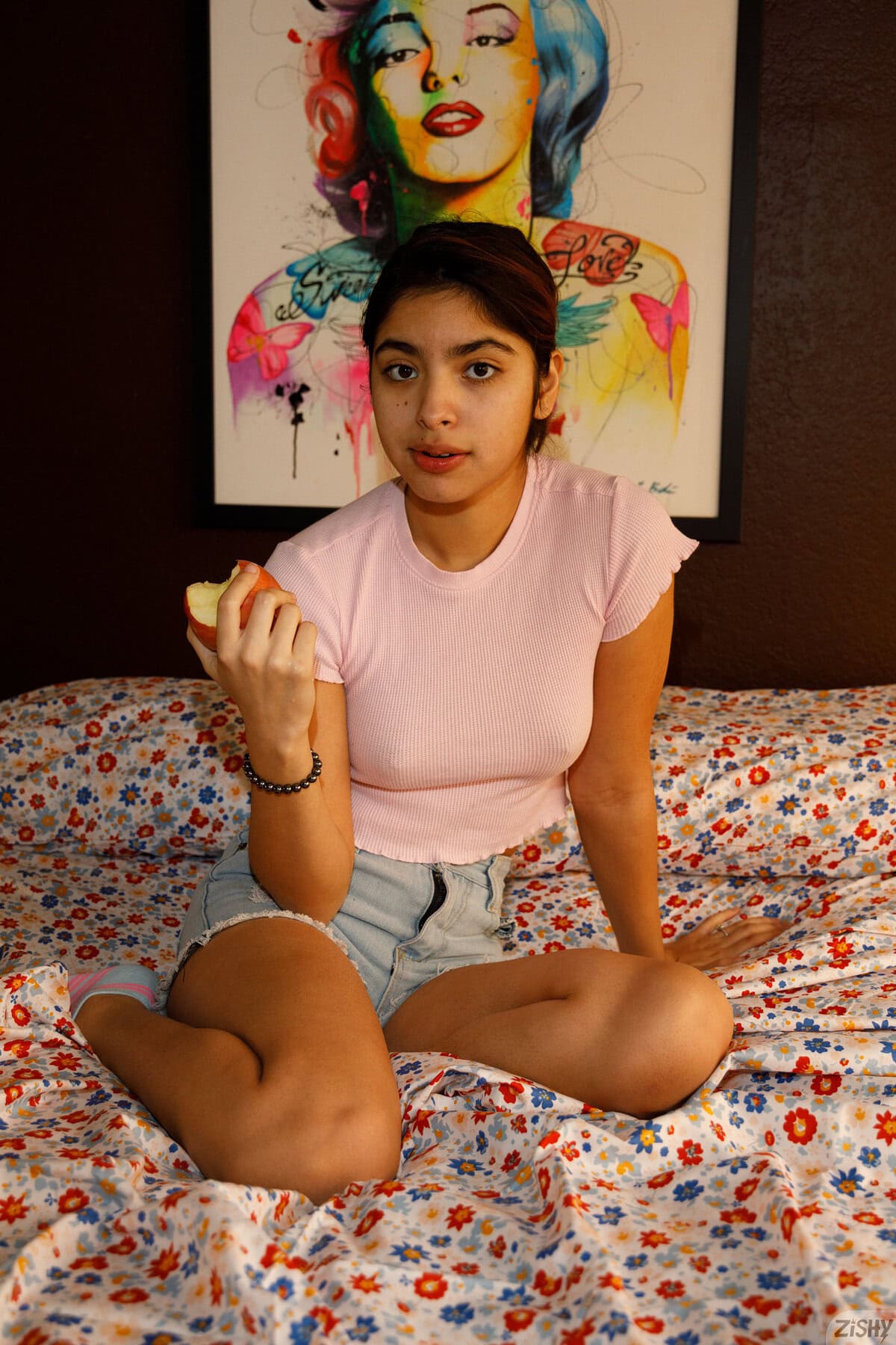 Hazel Heart poses on the bed, showcasing her slim, sexy body and natural curves